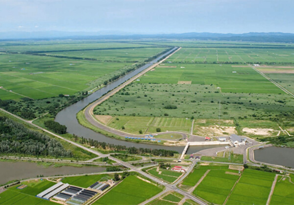 La station de pompage de drainage sud bloque presque le bassin de régulation (à droite) et le cours d&#39;eau ouest (à gauche). Le long cours d&#39;eau au centre est le canal de drainage principal ©Péninsule d&#39;Oga/Géoparc d&#39;Ogata