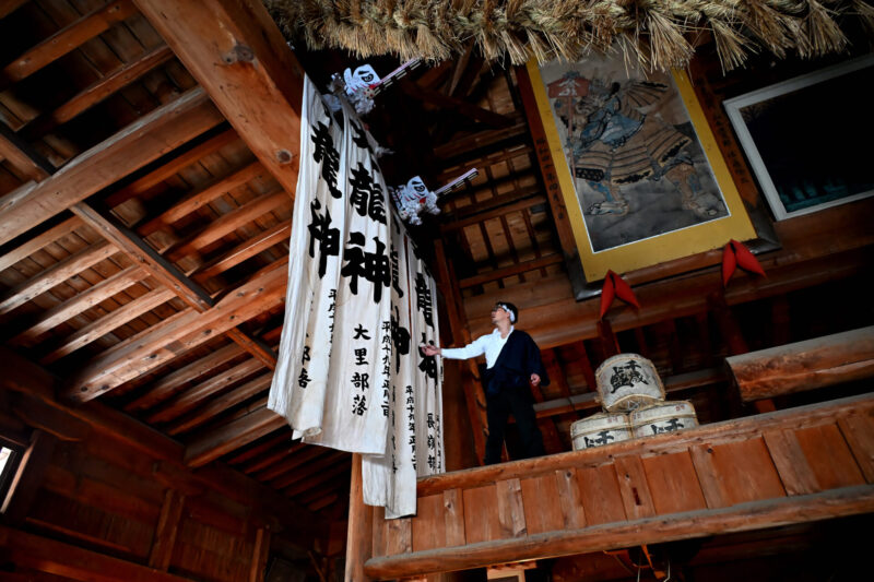Banderas grandes y pequeñas del dios dragón colgadas de las barandillas de cada aldea