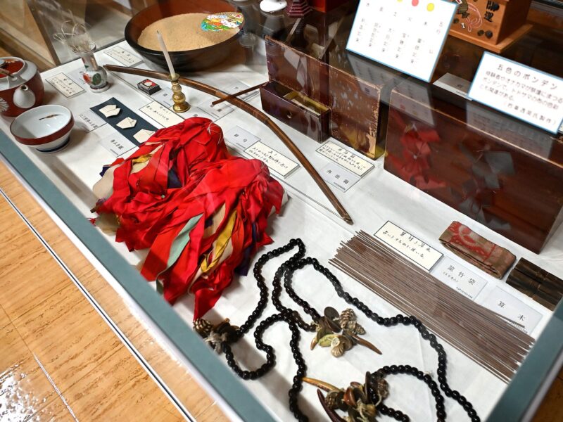 Onakama ritual implements such as a todosamu (a type of samurai doll), prayer beads, and a bow. (Collection of Nakayama Town Historical and Folk Museum)