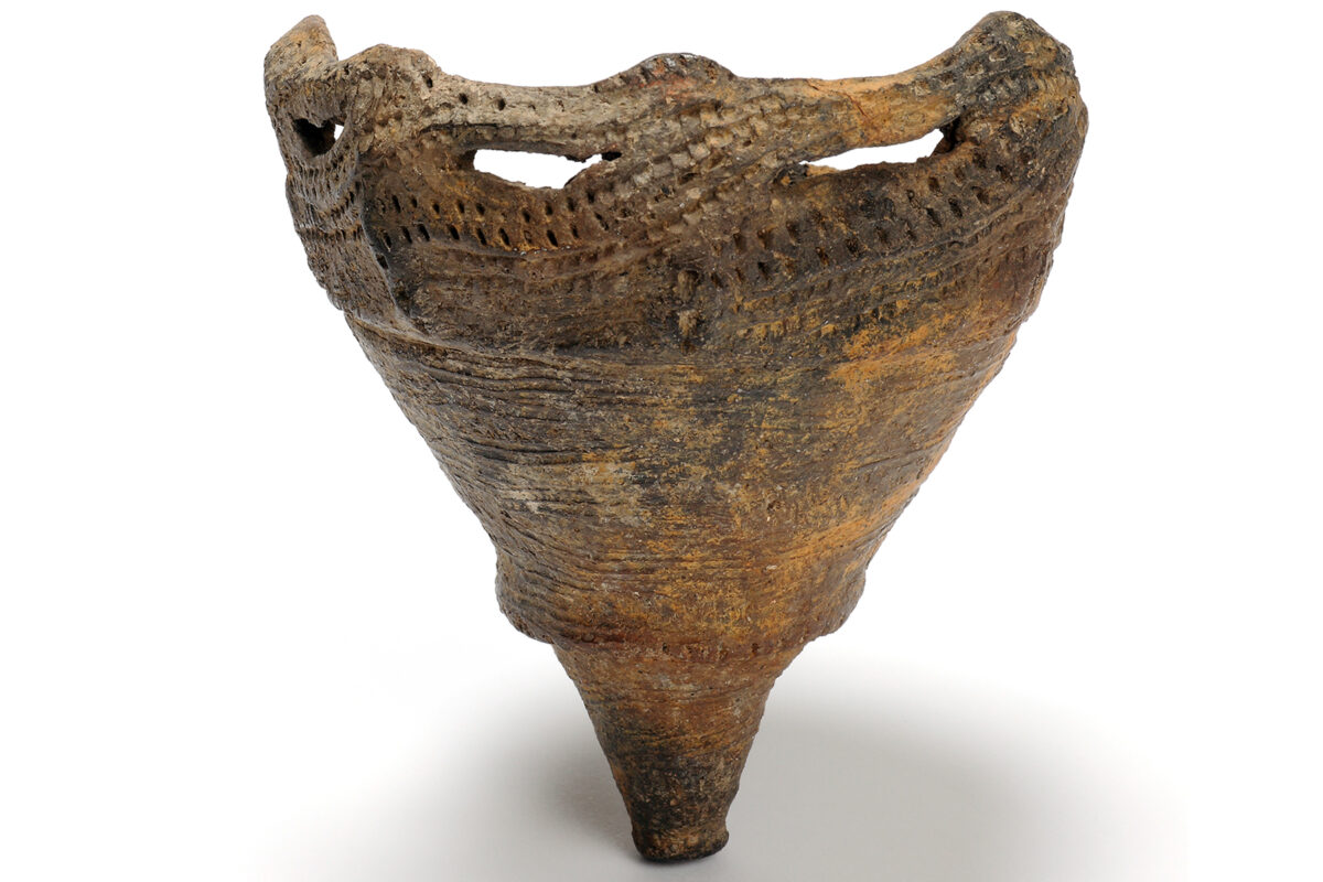 古代陶瓷器皿,宽阔的穿孔口沿,锥形器身,棕色纹理表面。.