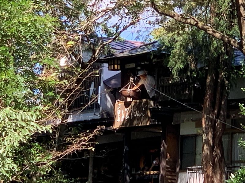 代金が入ったかごを引き上げる郭公だんごの店員